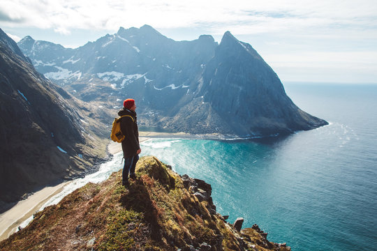 Man stand on cliff edge alone enjoying aerial view backpacking lifestyle travel adventure outdoor vacations
