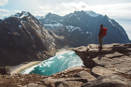 Man stand on cliff edge alone enjoying aerial view backpacking lifestyle travel adventure outdoor vacations