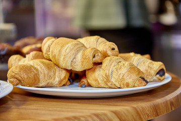 Chocolate croissants sprinkled with powdered sugar lie on a plate
