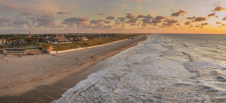 Wide shot of the ocean and the beach under the colorful sky captured in Domburg, Netherlands