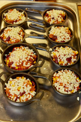 Cooking chili con carne in small pots in a restaurant.