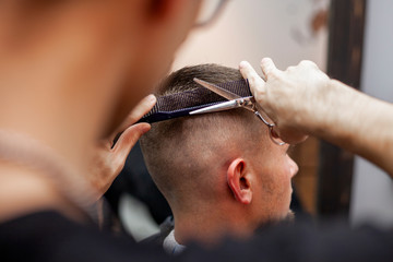 handsome guy get a haircut at the hairdresser, Kazakh hairdresser cuts manually with scissors and a...