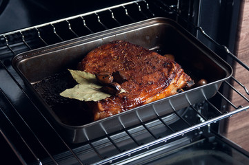 Cooking pork meat in the oven in the kitchen. Grilled pork ribs in the oven. Juicy meat cooked at home.