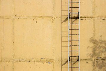 Old ladders on blank yellow wall