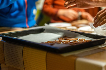 Mom and son putting gingerbread cookies on the pan for baking