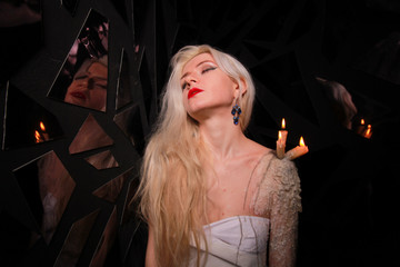 mystical girl with candles that stand on wax on the girl's skin
