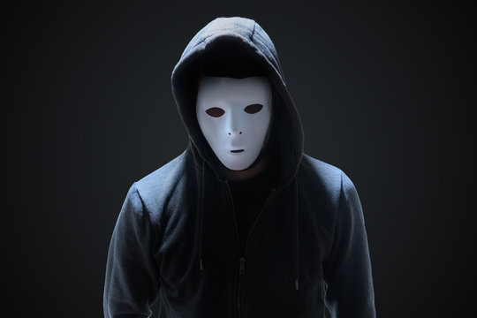 Masked anonymous hacker on black background.