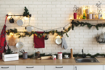 Interior white kitchen with lights and red christmas decorations