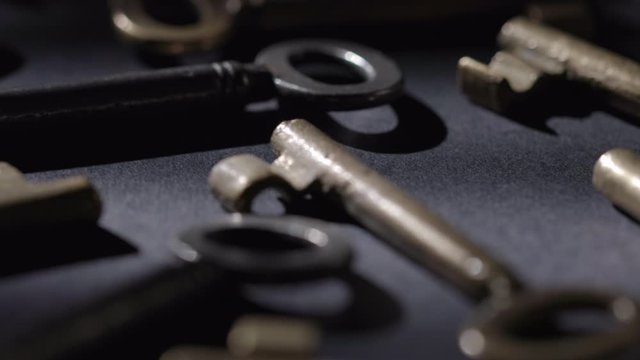 Old keys rotating over black background