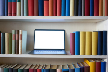 Laptop in bookshelf at home