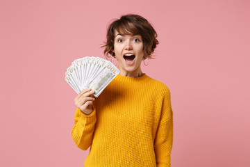 Shocked young brunette woman girl in yellow sweater posing isolated on pastel pink background...