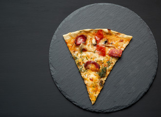 triangular slice of pizza with smoked sausages, mushrooms, tomatoes, cheese
