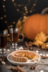 Yellow pumpkin pie orange  pumpkins with yelllow dry autumn leaves decor on dark table background.Harvesting,autumn and Thanksgiving concept