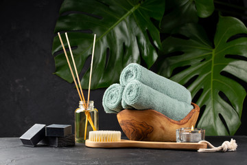 Spa and bath concept. Green tea scrub, coal black soap, eucalyptus, oil, sea stones, towels and...