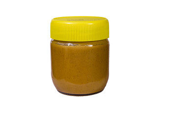 Glass jar with peanut butter isolated on a white background