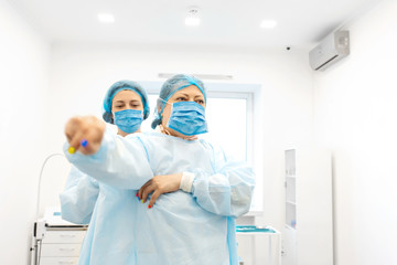 A nurse dresses a surgeon in a sterile suit before surgery