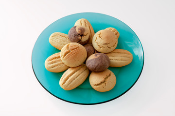 Sweet cookies on turquoise colored glass dish isolated on white background.