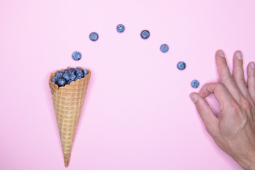 Berry ice cream. Blueberry in a horn. On a background for an inscription. hand and ice cream. top view vitamins concept. place for an inscription. berry love concept.