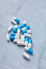 Creatine and Arginine capsules and BCAA amino acids.  Bodybuilding food supplements on bright stone background. Close up. Copy space. 