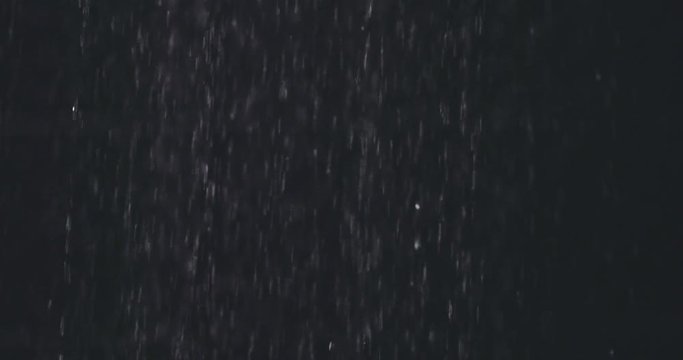 Water drops in hand. Shower or rain water drops falls in a female hand in slow motion 120fps. on a black background. Slow motion 240 fps, dolly shot, HD. 