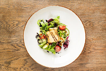 salad with fish on the wooden background
