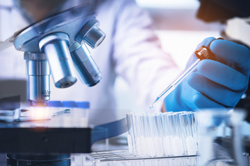 Scientist with equipment and science experiments ,laboratory glassware containing chemical liquid...