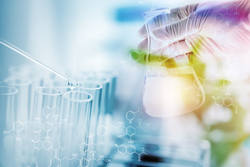 Dropper over test tube dropping sample chemical into sample herbal plaint , biotechnoloy research...