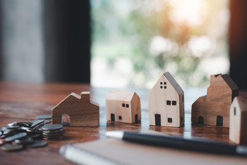 House model with money coins and notebook.House buying planning ideas