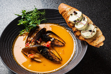 seafood soup with toast on the black background