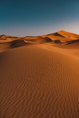 Vertical shot of a peaceful desert under the clear blue sky captured in Morocco