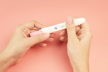 Female hands holding a  positive pregnancy test.