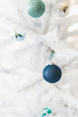 christmas tree with white frosted snow style and blue and silver toned baubles decoration