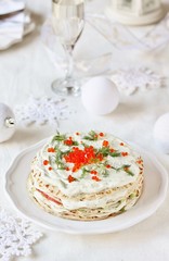 crep cake for Christmas and New Year. Decor with red caviar as New Year balls and dill as sprigs of spruce. Snack cake with salmon, avocado and soft cheese. Festive decor of the table for Christmas.