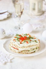 crep cake for Christmas and New Year. Decor with red caviar as New Year balls and dill as sprigs of spruce. Snack cake with salmon, avocado and soft cheese. Festive decor of the table for Christmas.