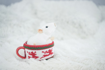 Obraz premium beautiful red mug with trendy sweater on it with white mouse inside. rat as a symbol of the year. nobody. white background.