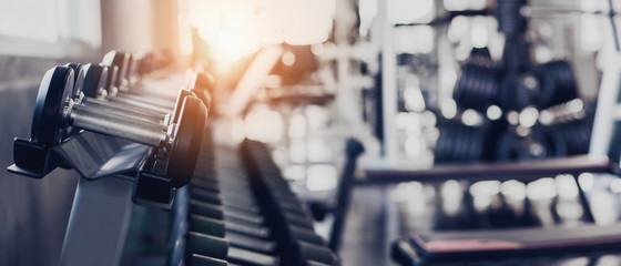 gym interior background of dumbbells on rack in fitness and workout room