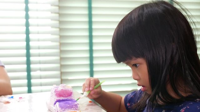 Asian girl child painting  paint brush.