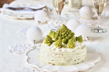 crep cake for Christmas and New Year.  Christmas tree decorations cabbage romanesco. Snack cake with salmon, avocado and soft cheese. Grains of cottage cheese play the role of snowdrifts.