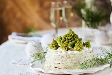 crep cake for Christmas and New Year.  Christmas tree decorations cabbage romanesco. Snack cake with salmon, avocado and soft cheese. Grains of cottage cheese play the role of snowdrifts.