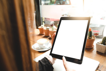 tablet and cup of coffee on wooden table