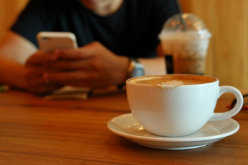 hot coffee drink in cafe and people working on smart app mobile phone