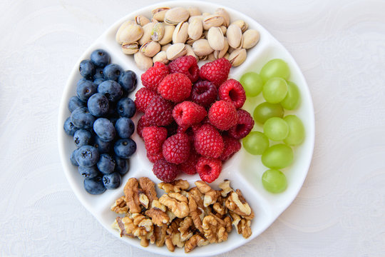 healthy nutrition, berries and nuts. wild strawberries, grapes, blueberries, walnuts, pistachios. Eco food concept. Mixed berries and nuts. DSLR royalty free image, healthy breakfast or snack option m