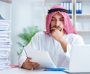 Arab businessman working in the office doing paperwork with a pi