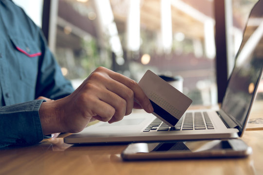 Man using credit card with shopping online concept at cafe.