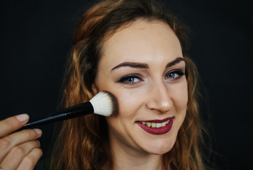 Portrait, beautiful girl, make-up, with smile posing on black background, makeup, powder, eye shadow, mascara, lipstick, eyeshadow