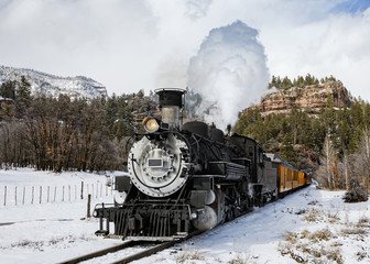 Vintage Steam Train Billowing Smoke as it Moves Through the Mountains.