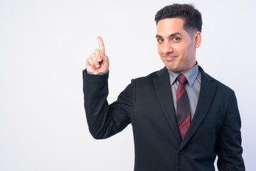 Portrait of handsome Persian businessman in suit pointing up