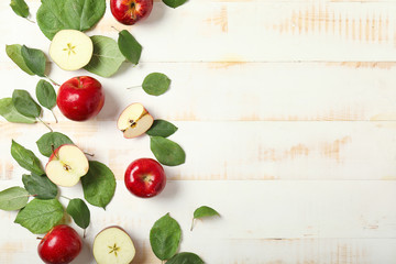 Fresh ripe apples on white wooden background