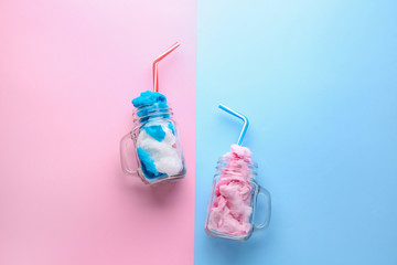 Jars with tasty cotton candy on color background