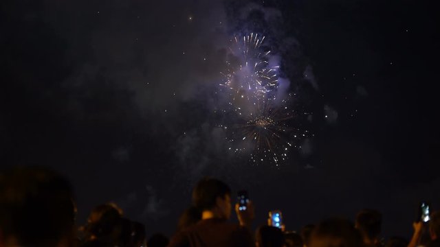 People watching fireworks and recording video with smartphones